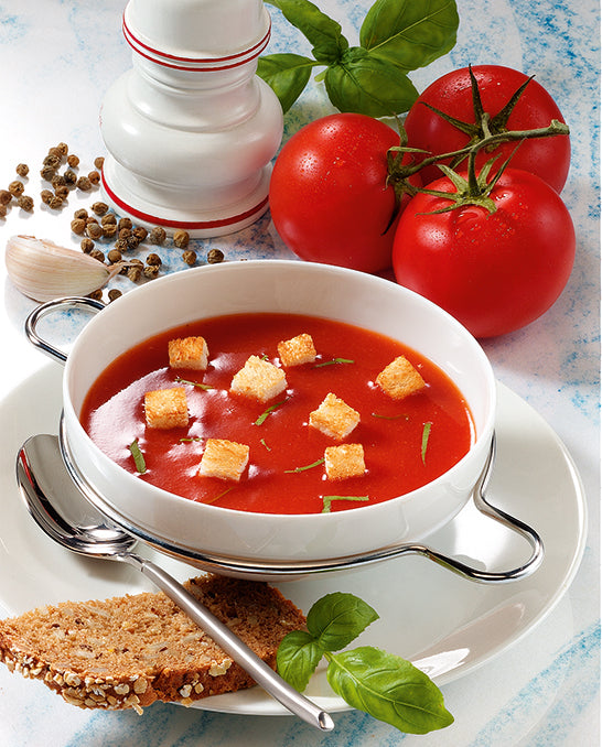 Tomatensuppe mit Croutons angerichtet dazu Brot