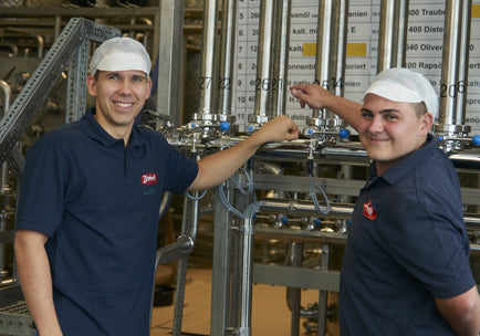 Two employees stand in front of a filling line