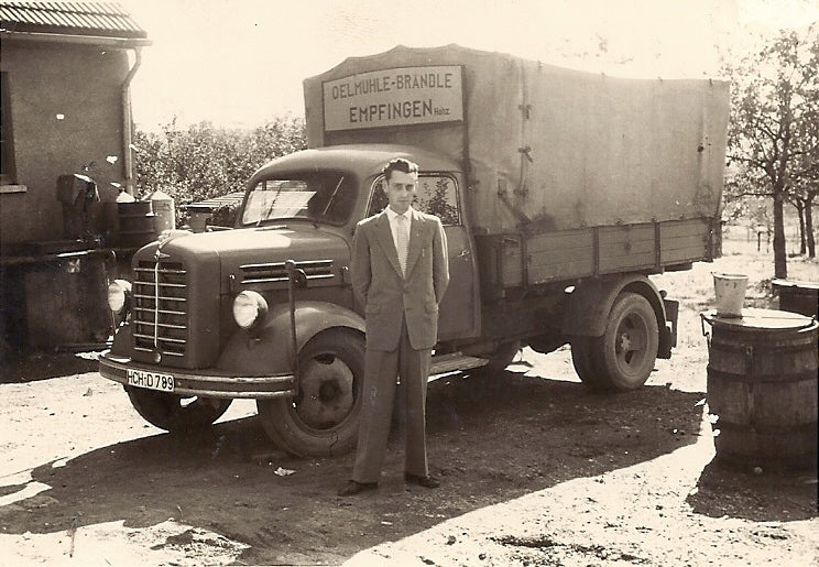 Pius Brändle stands in front of a truck that was used to deliver oil at the time. 