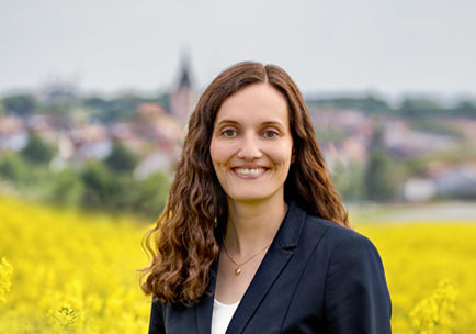 Simone Lamparter standing in the rape field with Empfingen in the background
